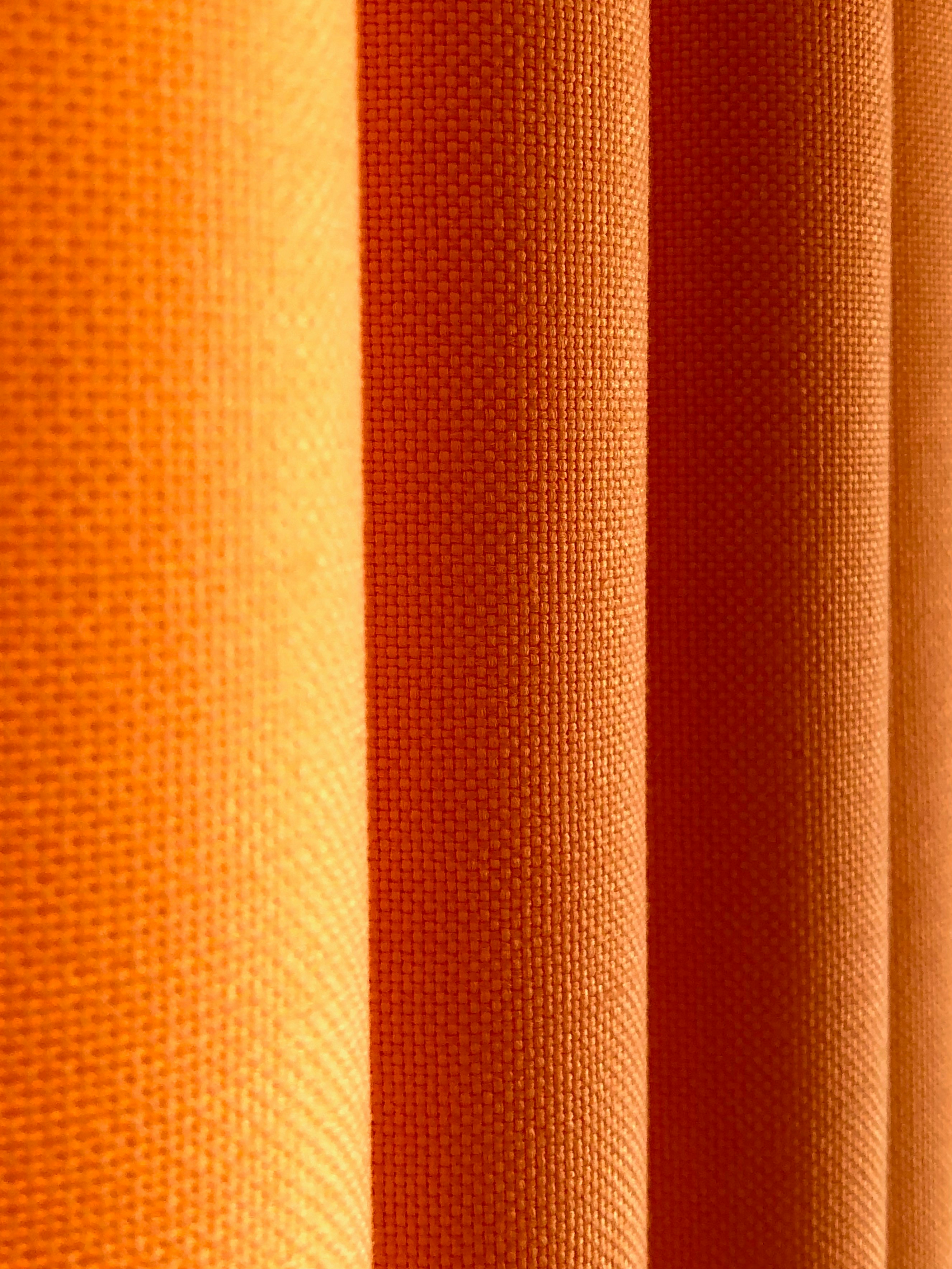 Photo of the fabric texture on an orange curtain