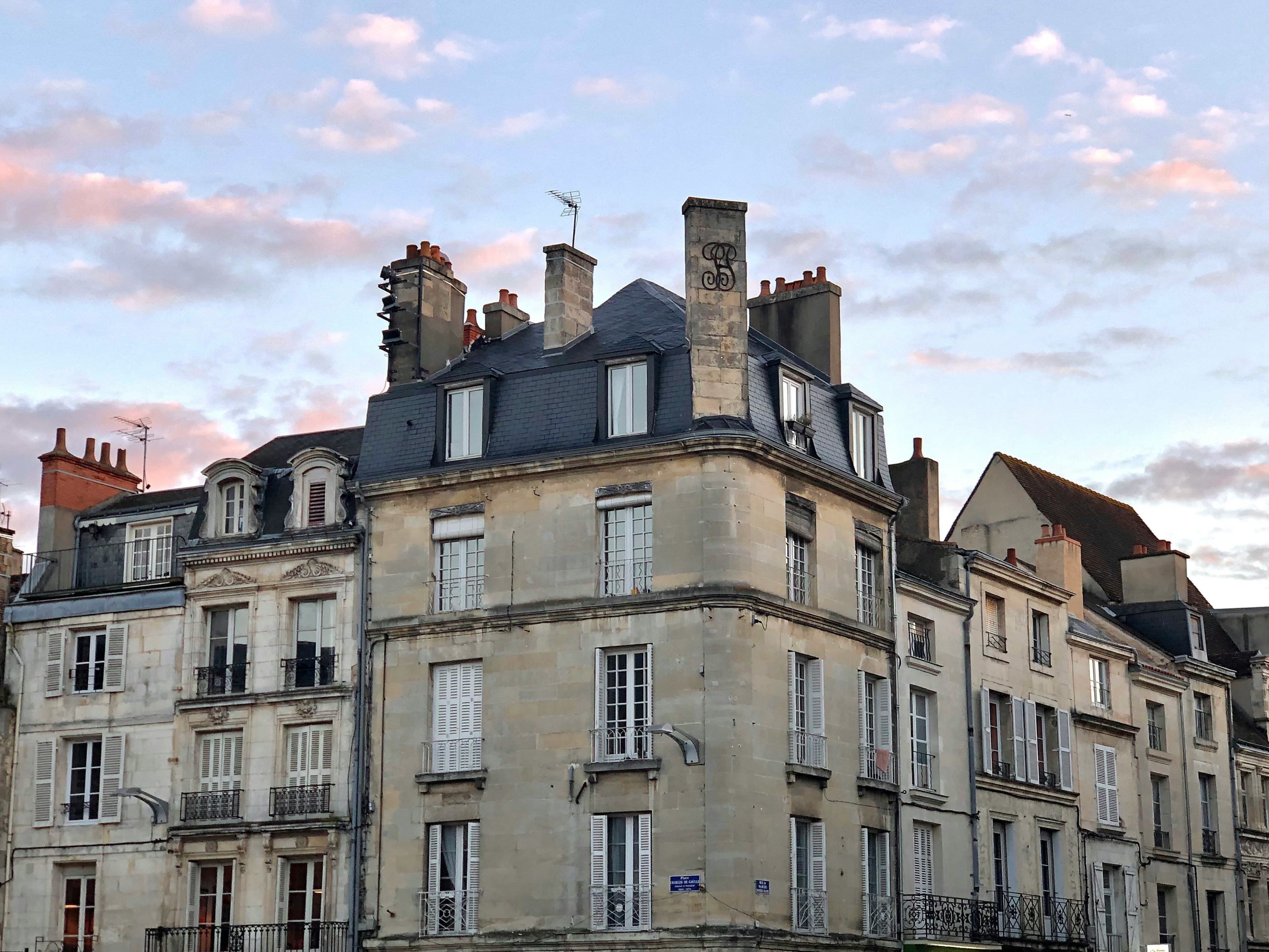 Photo of classic French buildings under a cloudy sunset sky