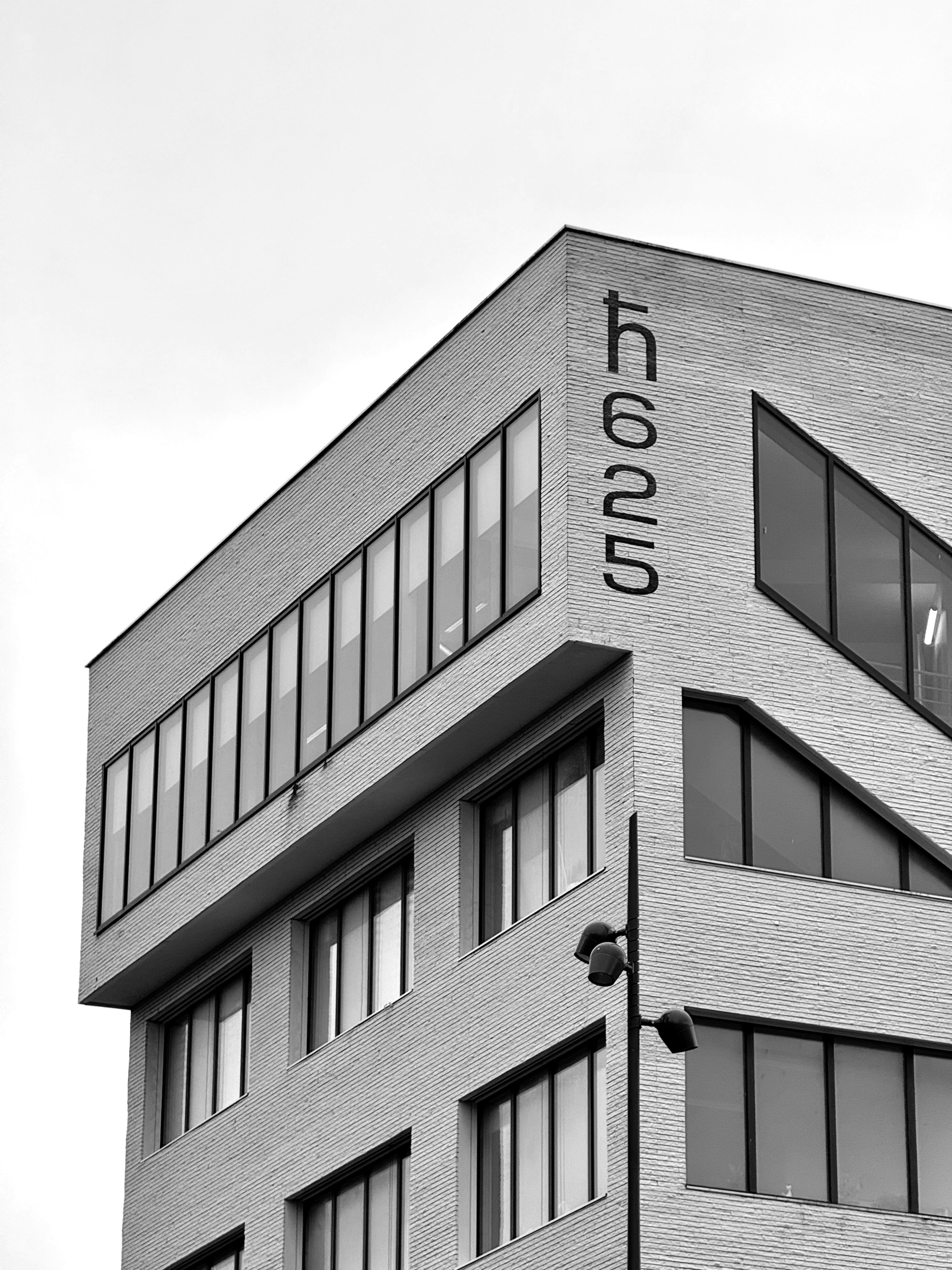 Black and white photo of a modern building with the text 'h625' written on it