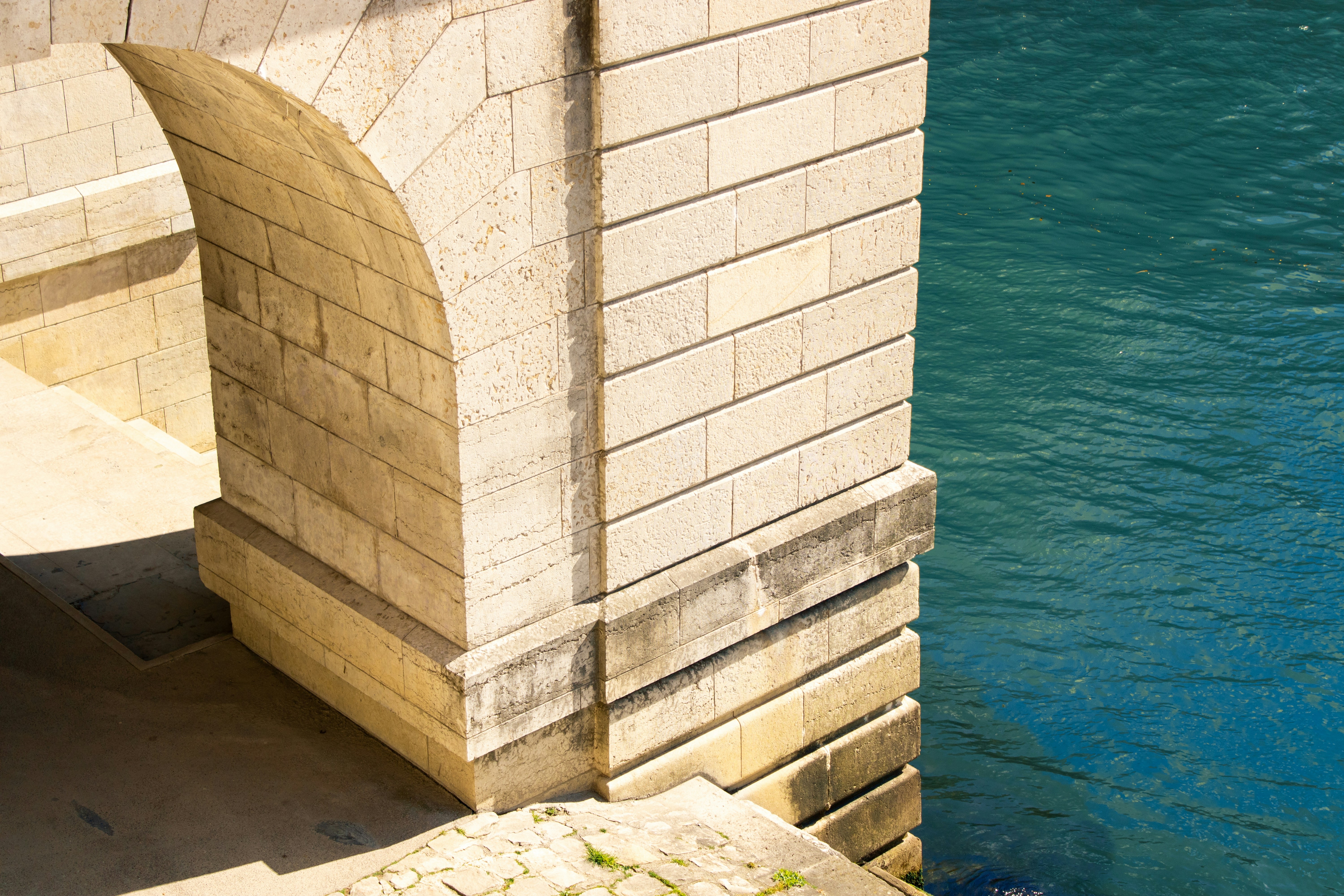 Photo of a limestone sidewalk next to a body of water