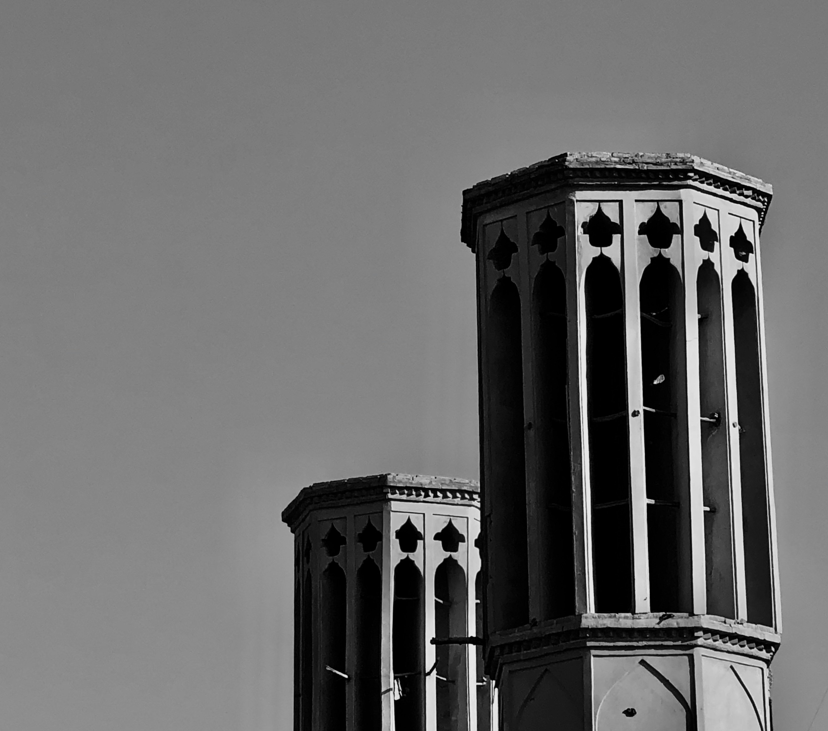 Black and white photo of two badguirs in Yazd, Iran